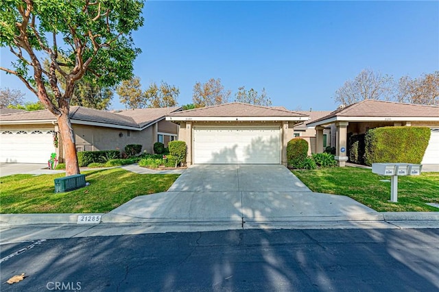 single story home with a garage and a front lawn