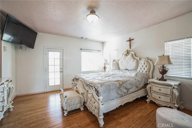 bedroom featuring wood-type flooring and a textured ceiling