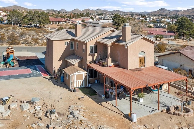 rear view of house featuring a mountain view and a shed