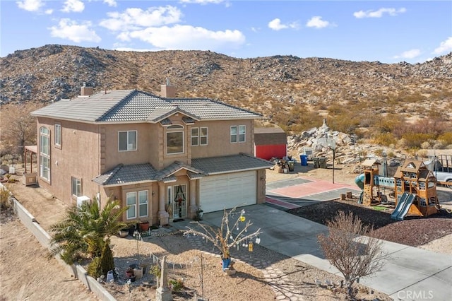 view of front of home featuring a playground, a mountain view, and a garage