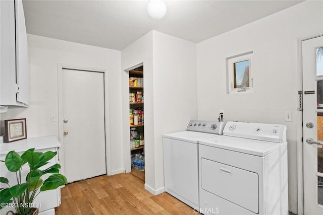 laundry area with independent washer and dryer and light hardwood / wood-style flooring