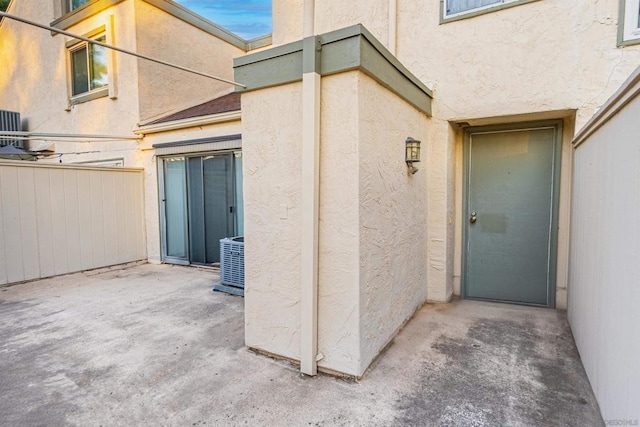 view of exterior entry featuring a patio area and central air condition unit