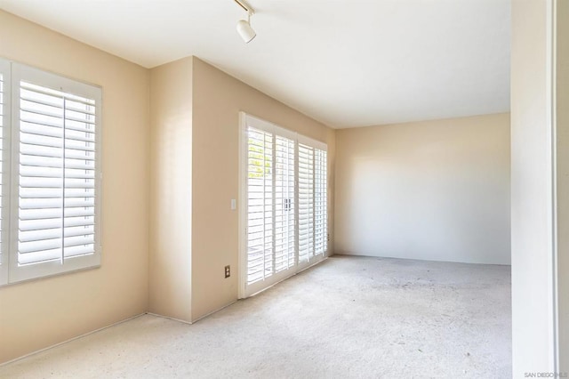 unfurnished room featuring track lighting