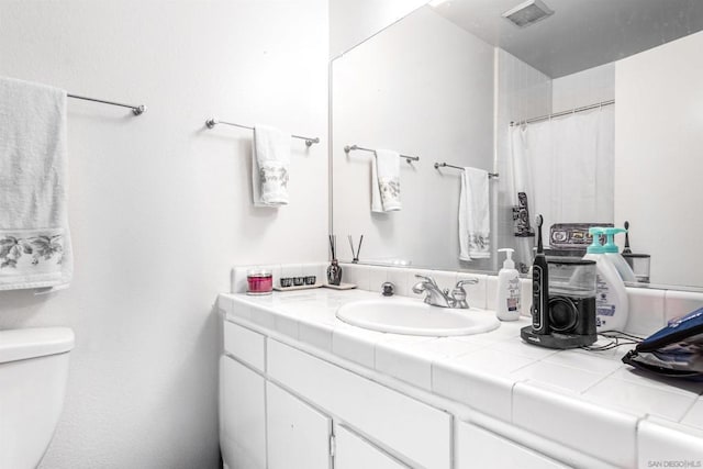 bathroom featuring toilet, vanity, and a shower with shower curtain