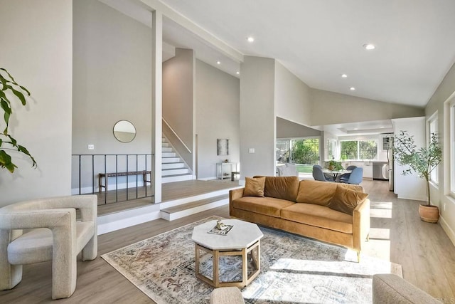 living room with high vaulted ceiling and light hardwood / wood-style floors