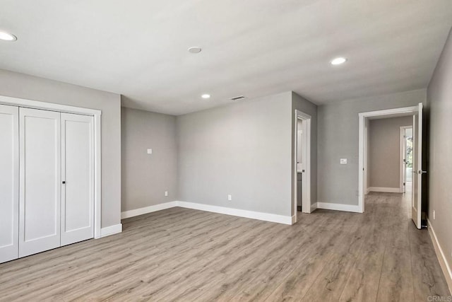 unfurnished bedroom with a closet and light hardwood / wood-style flooring