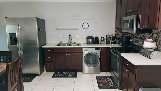 kitchen featuring sink, washer / clothes dryer, decorative backsplash, light tile patterned floors, and appliances with stainless steel finishes