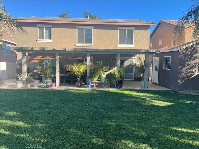 rear view of house featuring a pergola, a lawn, and a patio