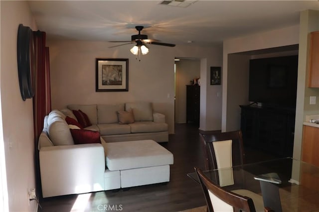 living room featuring ceiling fan and dark hardwood / wood-style flooring