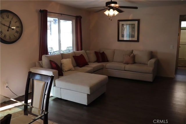 living room featuring ceiling fan and dark wood-type flooring