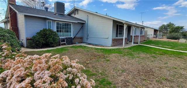 view of side of property with central AC and a yard