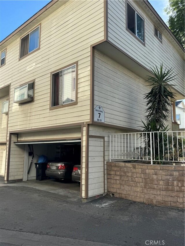 view of side of property with a garage and a wall unit AC