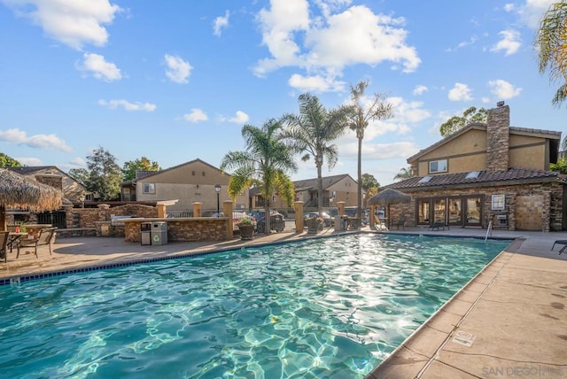 view of swimming pool with a patio and an outdoor kitchen