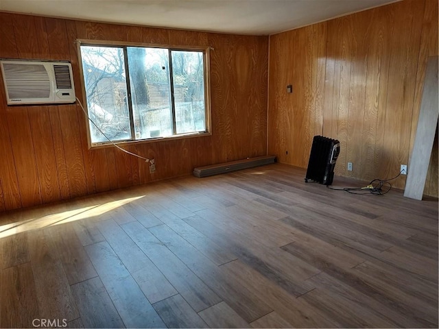 unfurnished room with hardwood / wood-style floors and wood walls