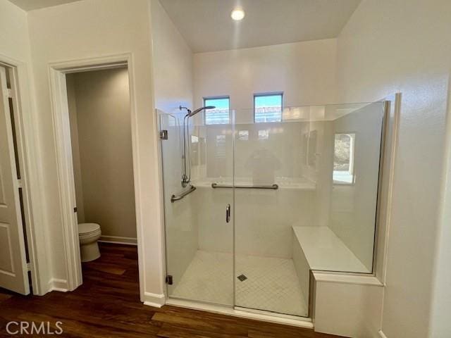 bathroom with toilet, wood-type flooring, and walk in shower