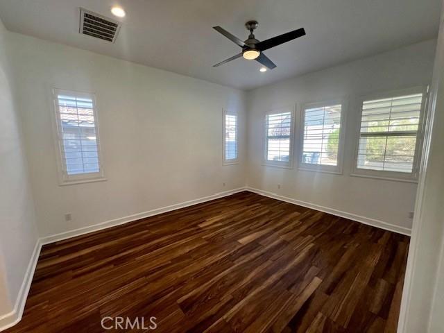 spare room featuring ceiling fan and dark hardwood / wood-style floors