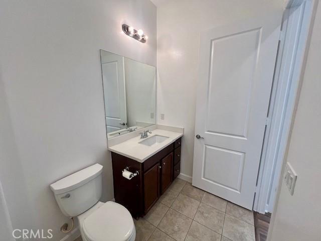 bathroom featuring toilet, vanity, and tile patterned flooring