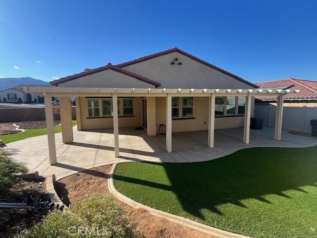 rear view of property with a yard and a patio