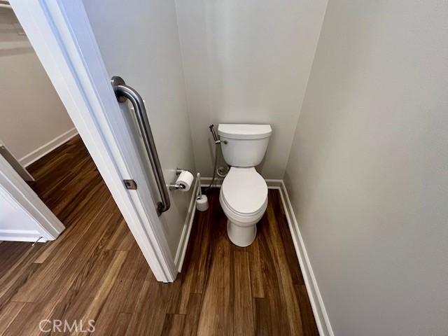 bathroom with hardwood / wood-style floors and toilet