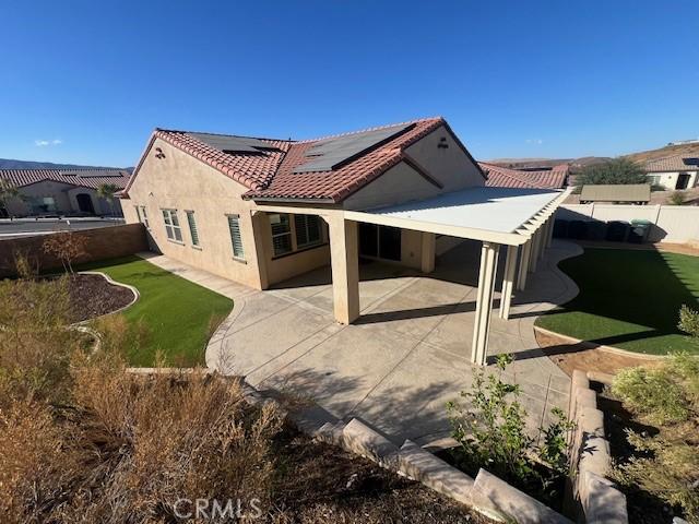 rear view of property featuring solar panels