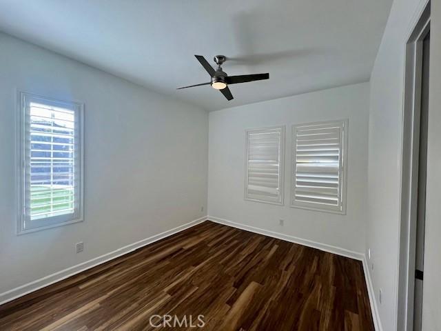 unfurnished room featuring ceiling fan and dark hardwood / wood-style floors