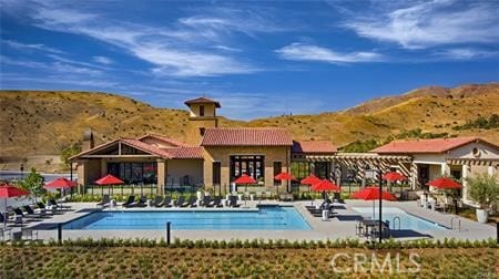 view of pool with a mountain view and a patio