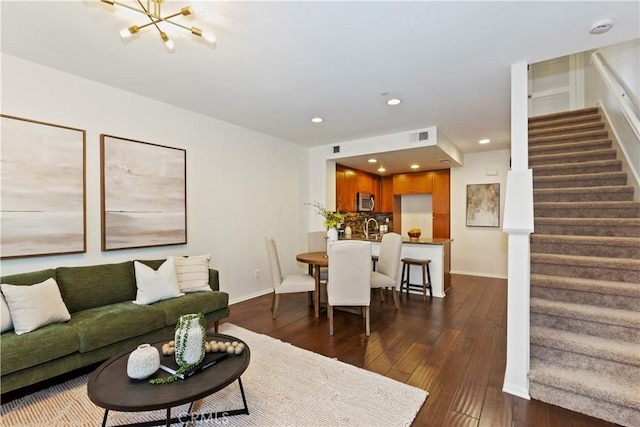 living room with dark hardwood / wood-style floors and a notable chandelier