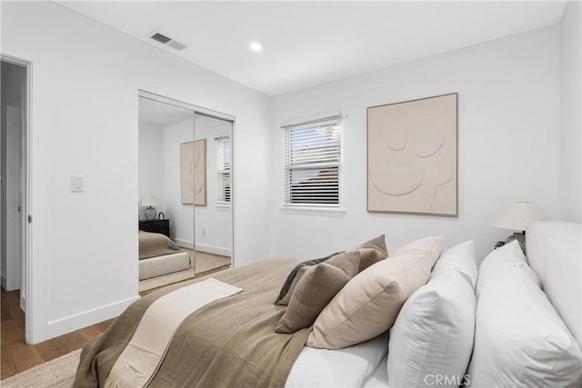 bedroom with light wood-type flooring and a closet