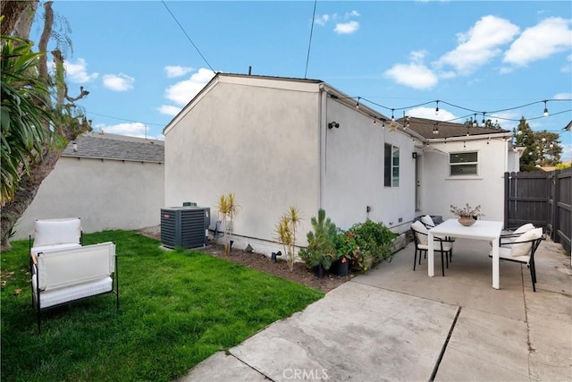 rear view of house with cooling unit, a patio, and a yard