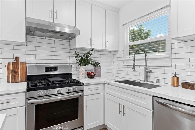 kitchen featuring stainless steel appliances, decorative backsplash, white cabinets, and sink