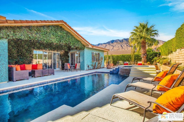 view of pool with a mountain view, an outdoor living space, an in ground hot tub, and a patio area