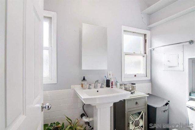 bathroom with a wealth of natural light and tile walls