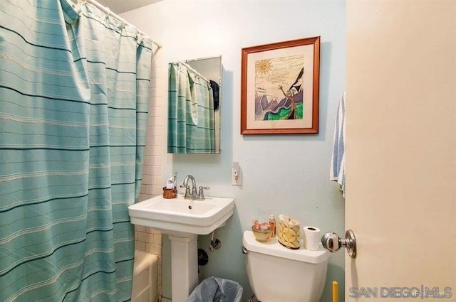 full bathroom with toilet, shower / bath combo with shower curtain, and sink