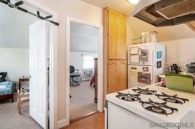 kitchen featuring light brown cabinetry, light carpet, range hood, and white appliances