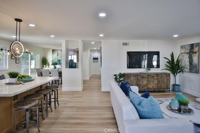 living room with light hardwood / wood-style floors and an inviting chandelier