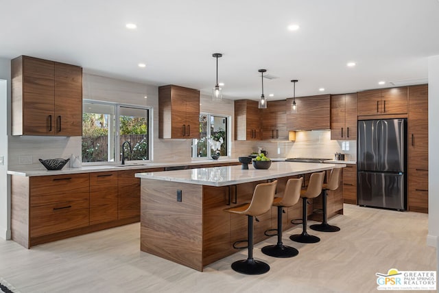 kitchen with appliances with stainless steel finishes, a center island, decorative light fixtures, a kitchen breakfast bar, and backsplash