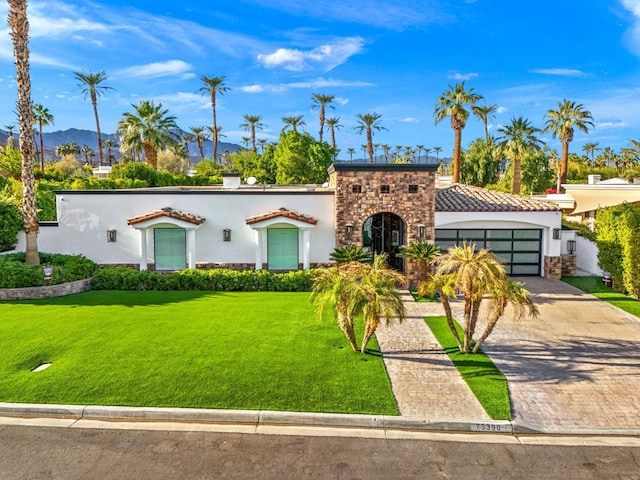 mediterranean / spanish-style house with a front yard and a garage