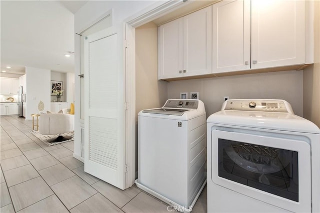 laundry room featuring light tile patterned floors, independent washer and dryer, and cabinets