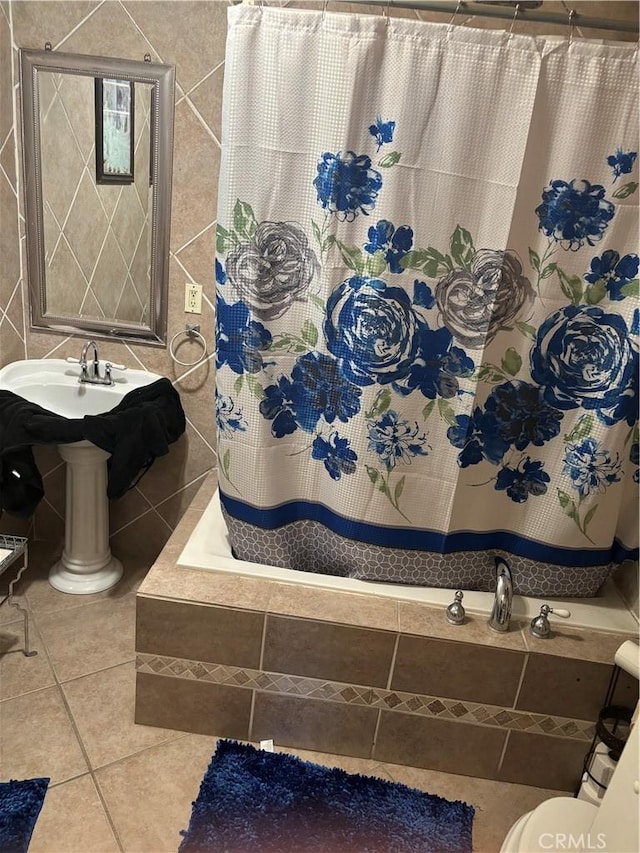 bathroom featuring toilet, tile patterned floors, and tile walls