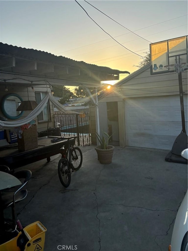 patio terrace at dusk featuring a garage