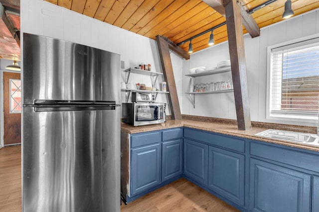 kitchen featuring stainless steel appliances, blue cabinetry, wood ceiling, and light wood-type flooring