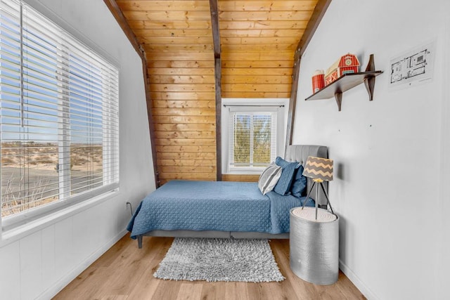 bedroom with lofted ceiling, wooden walls, wooden ceiling, and light wood-type flooring