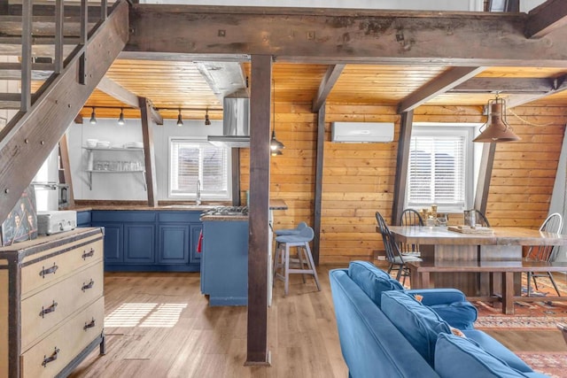 interior space featuring blue cabinetry, beam ceiling, hanging light fixtures, and wooden ceiling