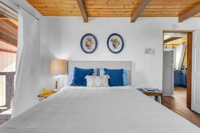 bedroom with beamed ceiling, hardwood / wood-style floors, and wooden ceiling