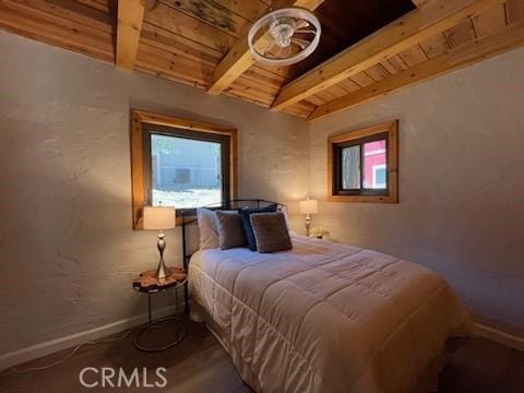 bedroom with multiple windows, lofted ceiling with beams, and wooden ceiling