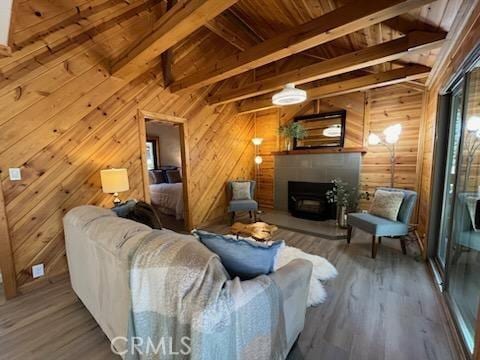 living room with hardwood / wood-style floors, beam ceiling, and wooden walls