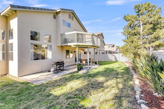 rear view of property featuring a patio area and a lawn