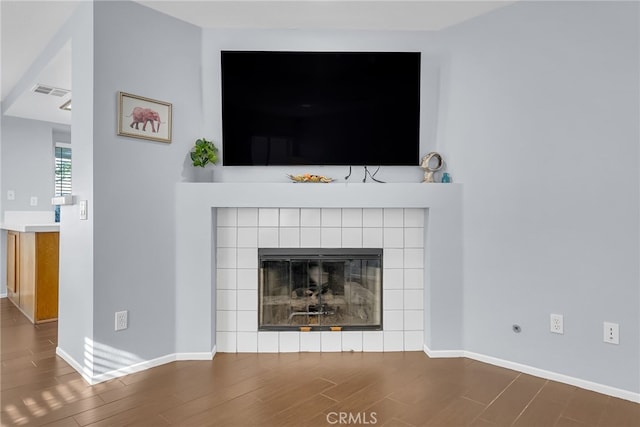 room details with hardwood / wood-style flooring and a tiled fireplace