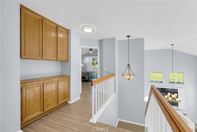 hallway with vaulted ceiling and light hardwood / wood-style flooring