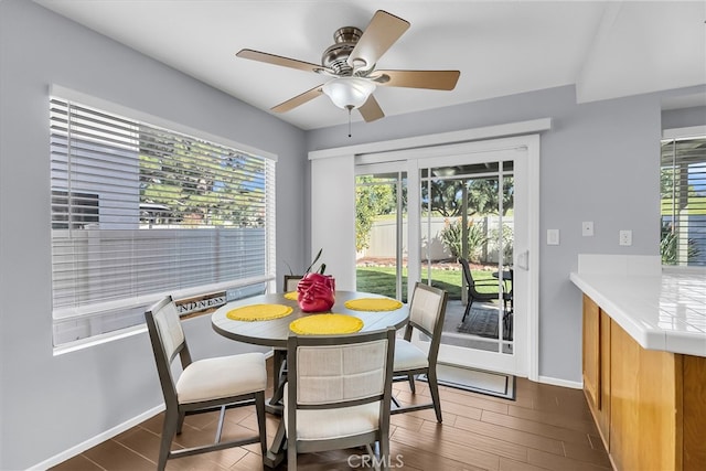 dining room with ceiling fan and dark wood-type flooring